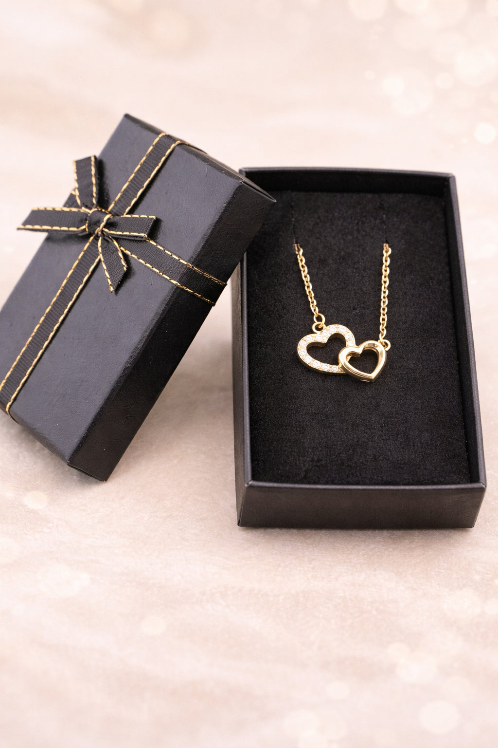 Collier amour femme duo cœur doré serti de pierres dans son écrin noir 