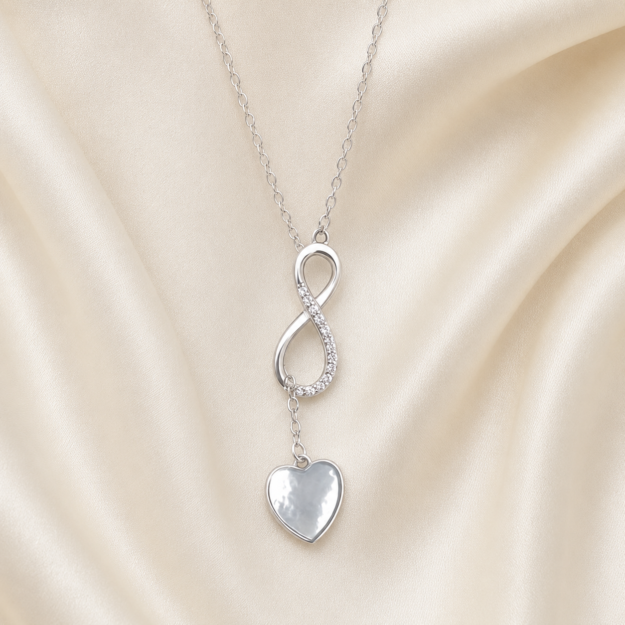 Collier cœur infini en argent 925 présenté sur soie ivoire