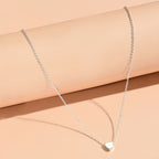 Collier petit cœur argenté fond neutre — bijou minimaliste femme Maison du Collier